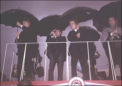 The Beatles arriving in Sydney, Australia. in the middle of a rain storm.