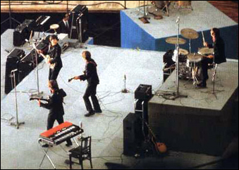 The Beatles performing at Budokan Hall, Tokyo, Japan, in their dark suits.
