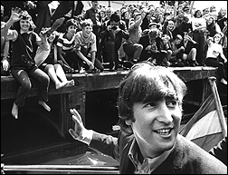 John Lennon waves to adoring fans during The Beatles arrival in Amsterdam, circa 1964.