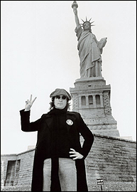 John Lennon poses in front of the Statue of Liberty.