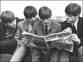 The Beatles gather together to read about themselves in British paper, The Mirror.